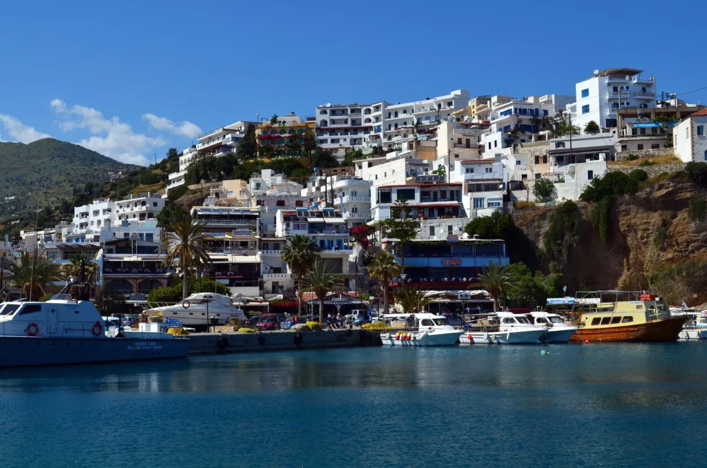 realistic view from afar of a port town with white houses and various ships