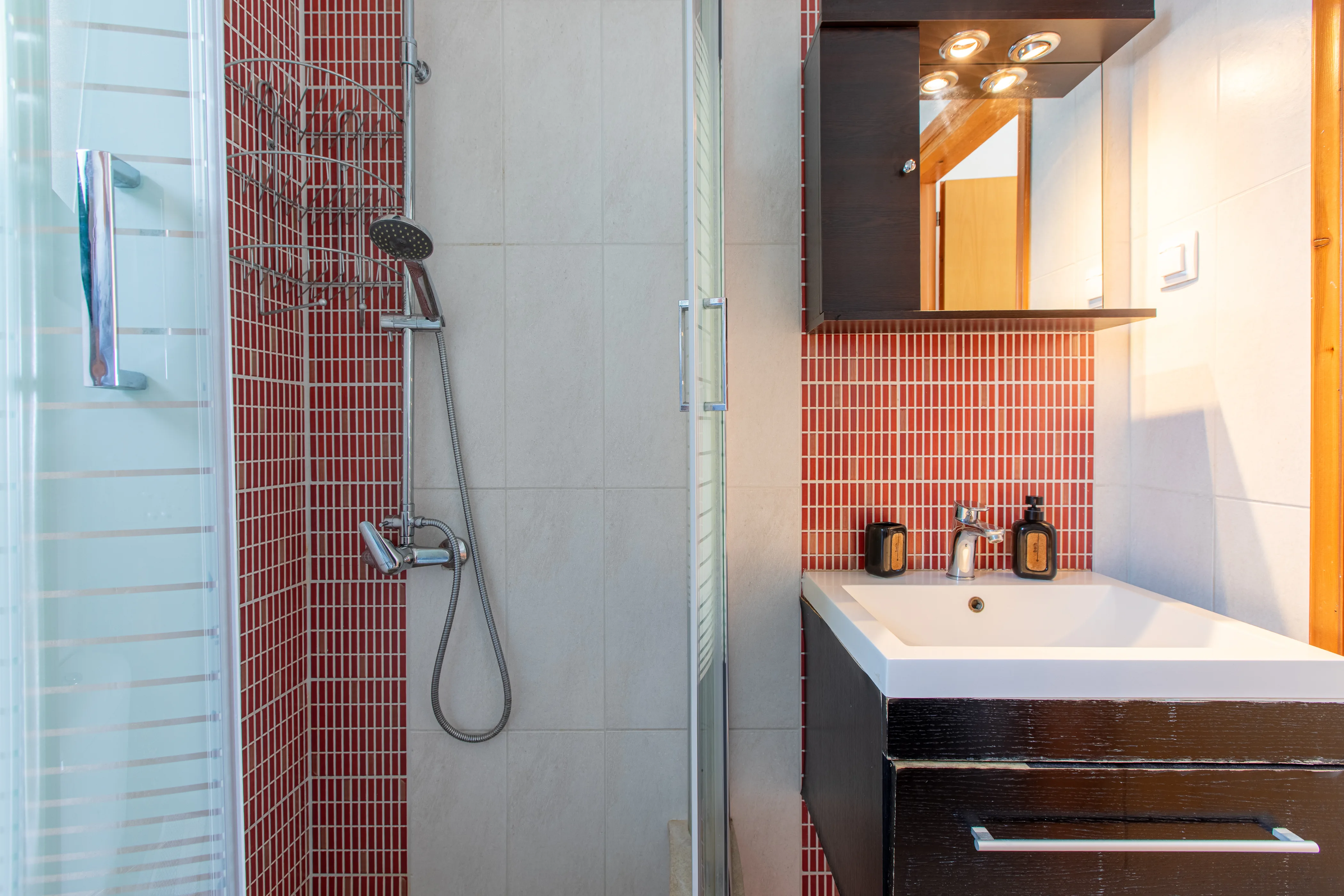 inside view of the apartment bathroom featuring the modern sink and the shower area at the left of it