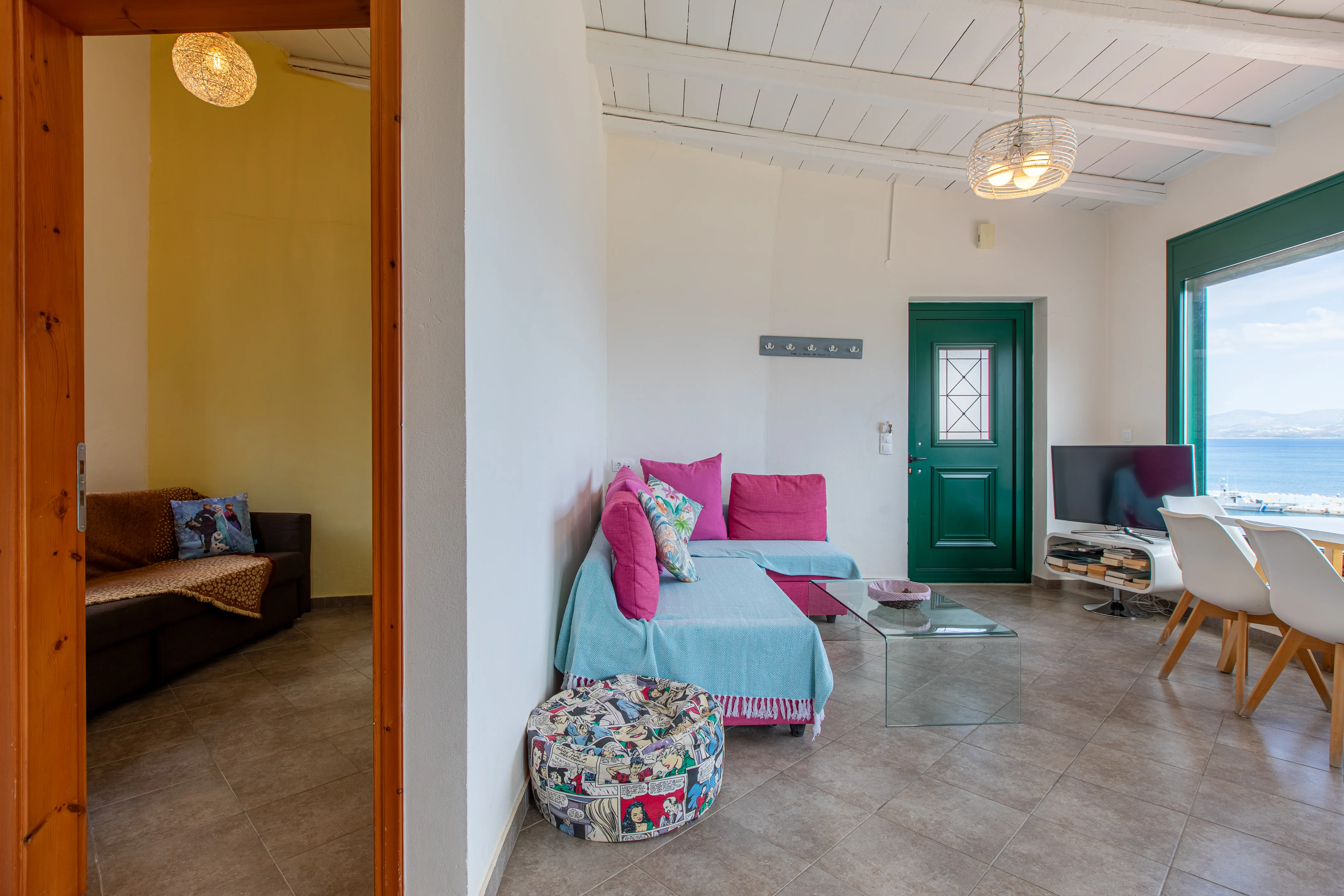 inside view of the apartment room featuring a large sofa and a wall separating two rooms