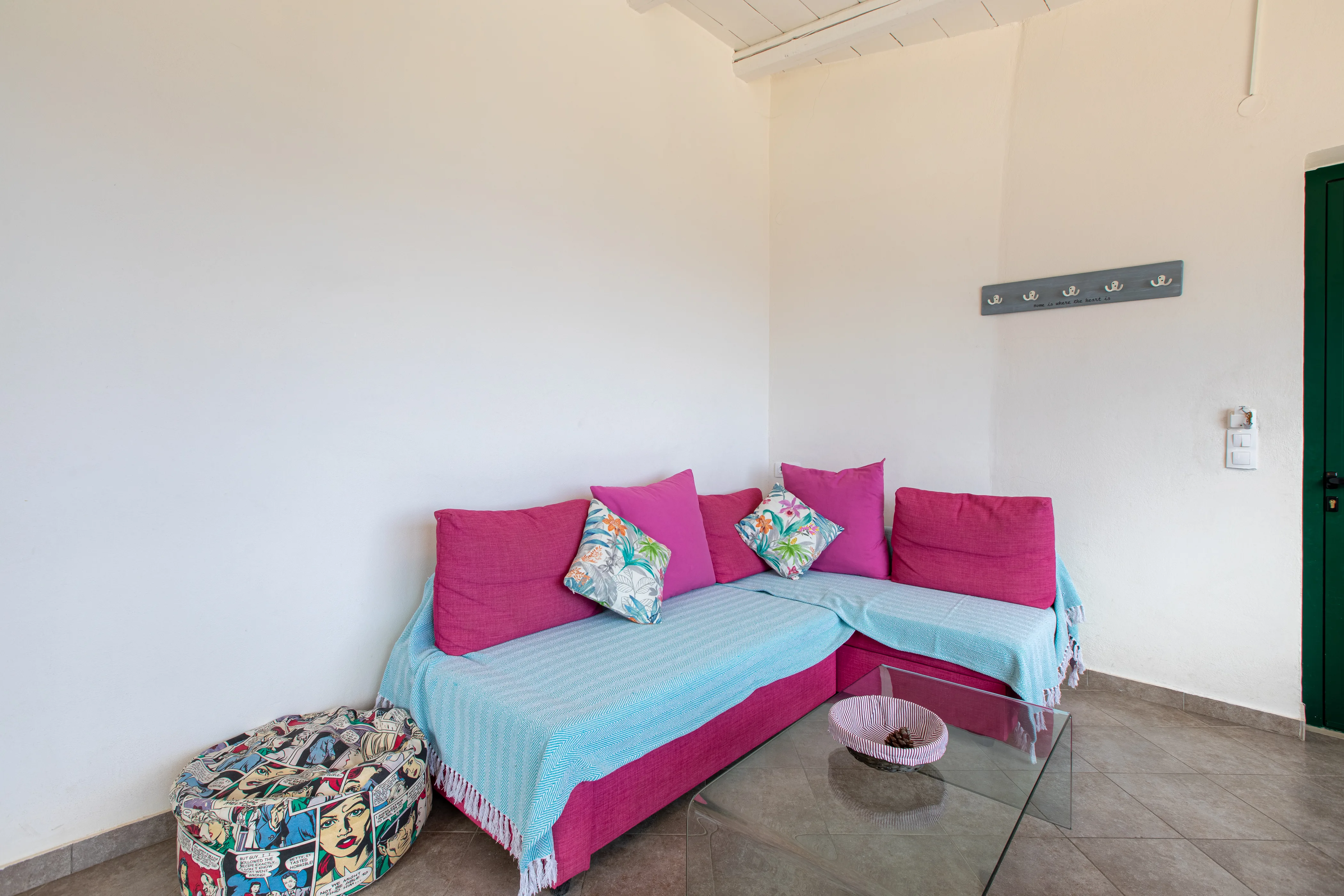 inside view of the apartment room featuring a large sofa with a glass table in front of it