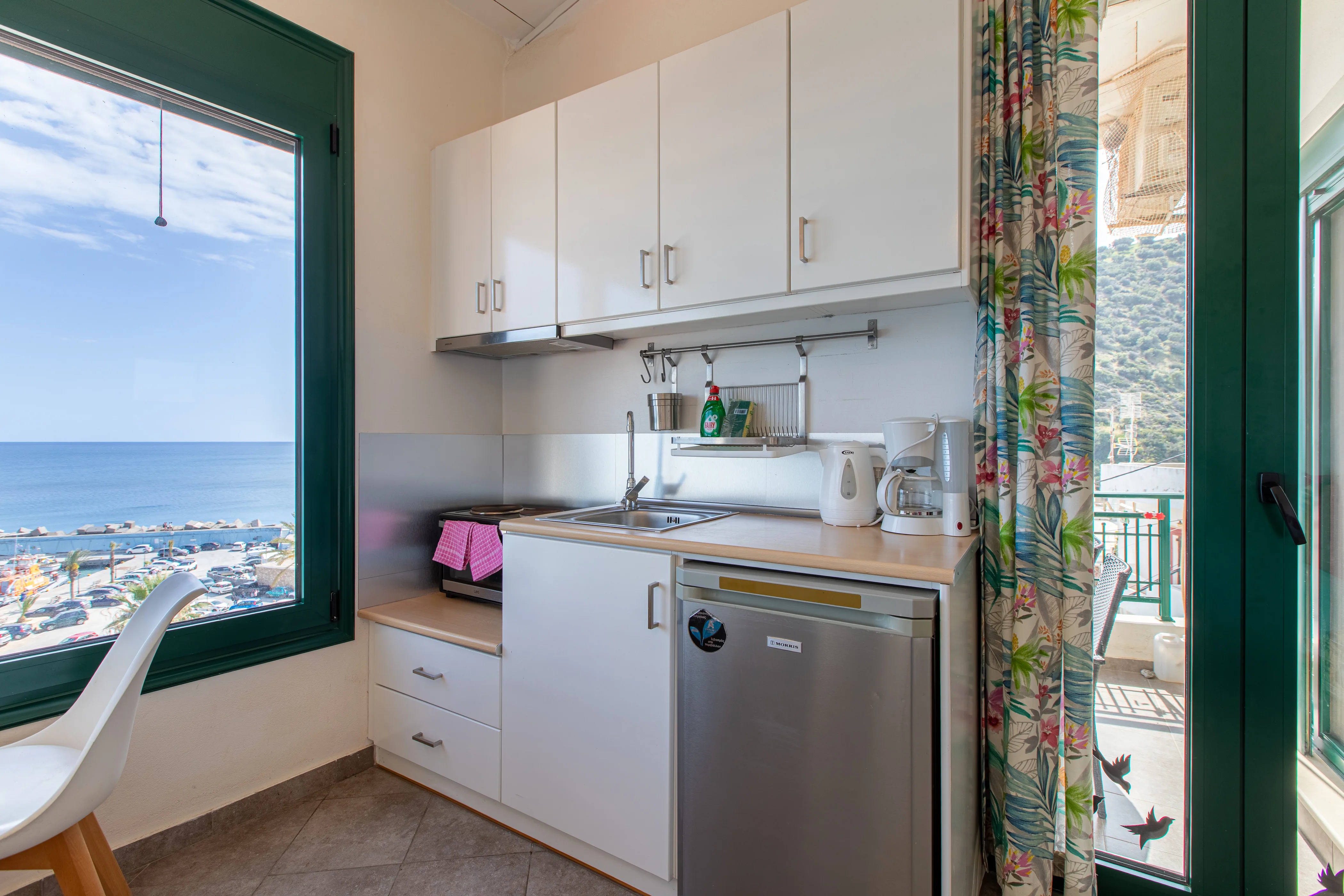 inside view of the apartment room featuring the kitchen area and a balcony door next to it