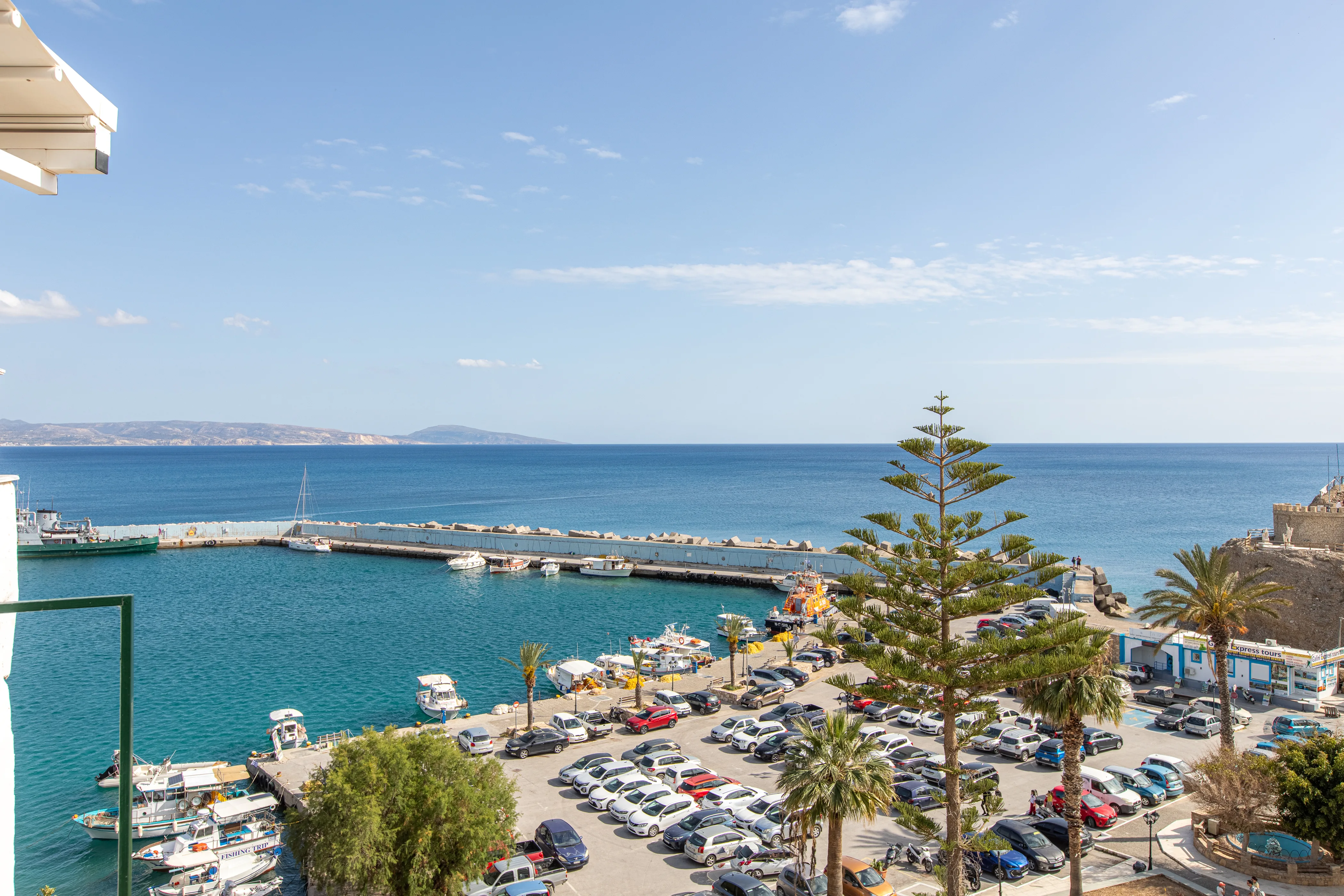 aerial view of a sea port with a parking filled with cars next to it