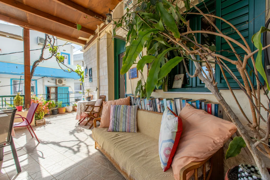 outside view of a balcony featuring a sofa with a row full of books in the back of it