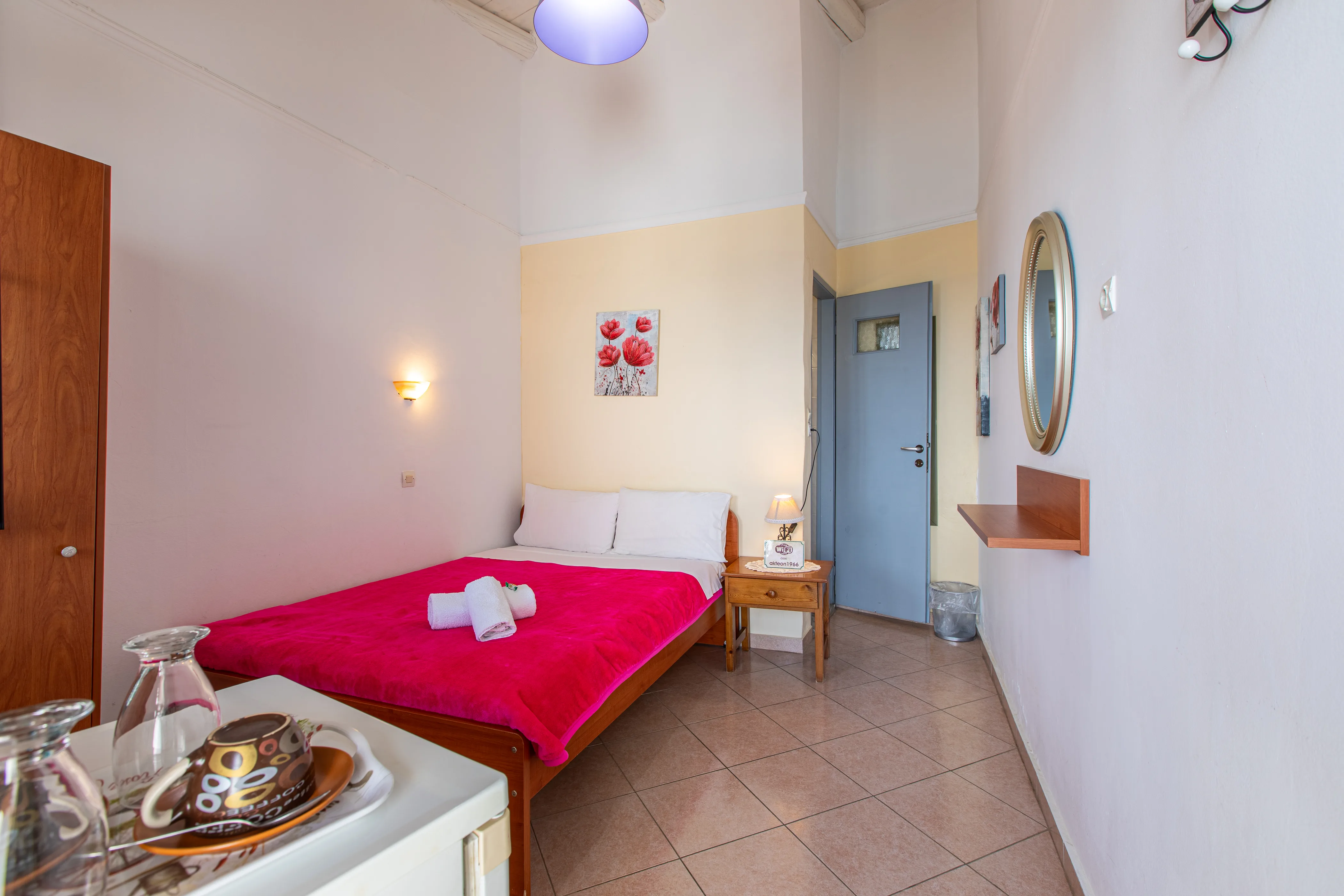 inside view of a room featuring a double bed with red bedsheets