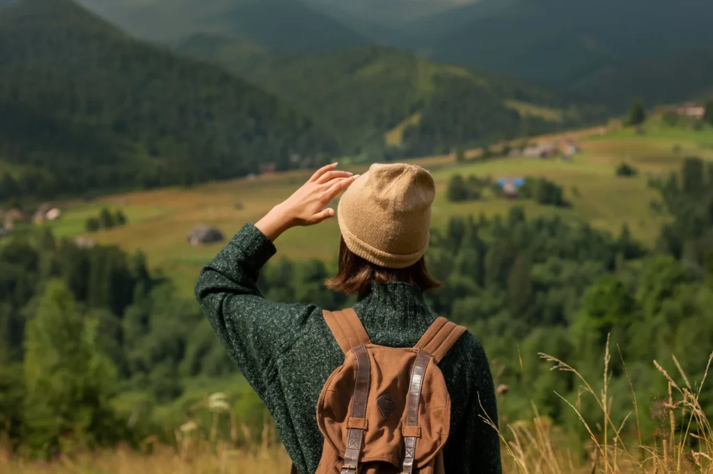 realistic photo of a woman wandering in a green landscape