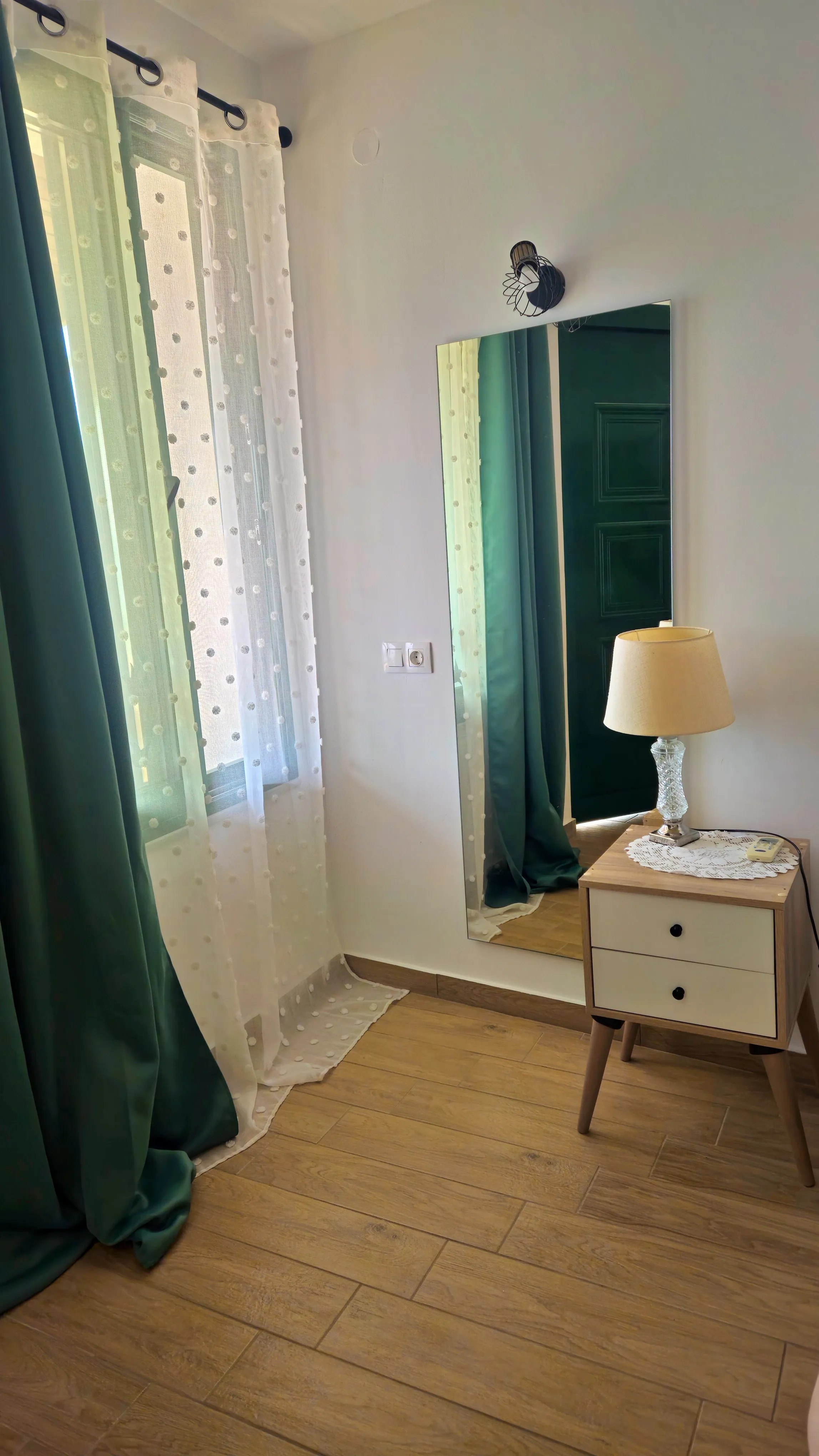 inside view of a hotel room featuring a wall large mirror and the window next to it
