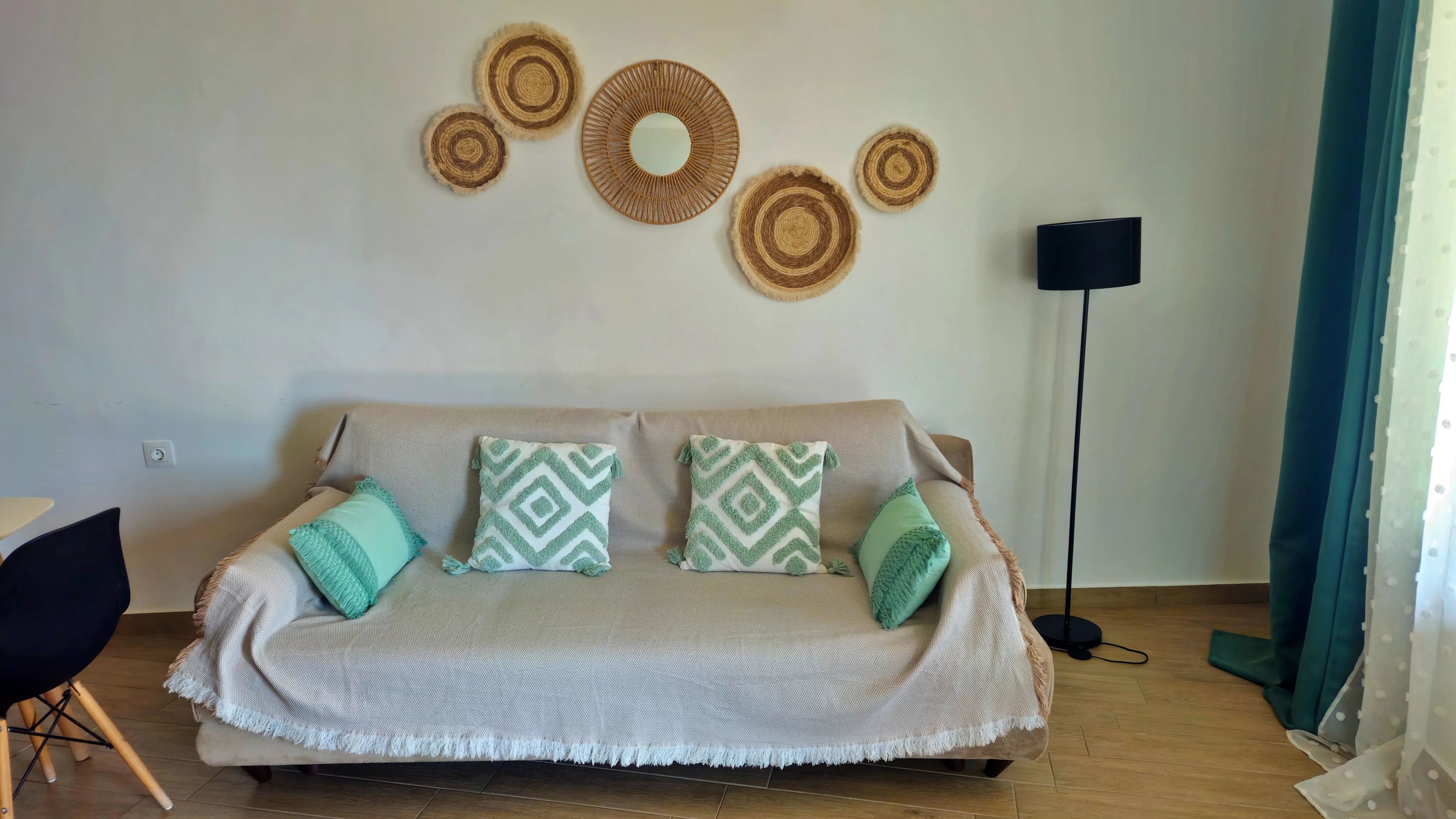 inside view of a hotel room featuring a sofa with artistic circle decoration on the wall above it
