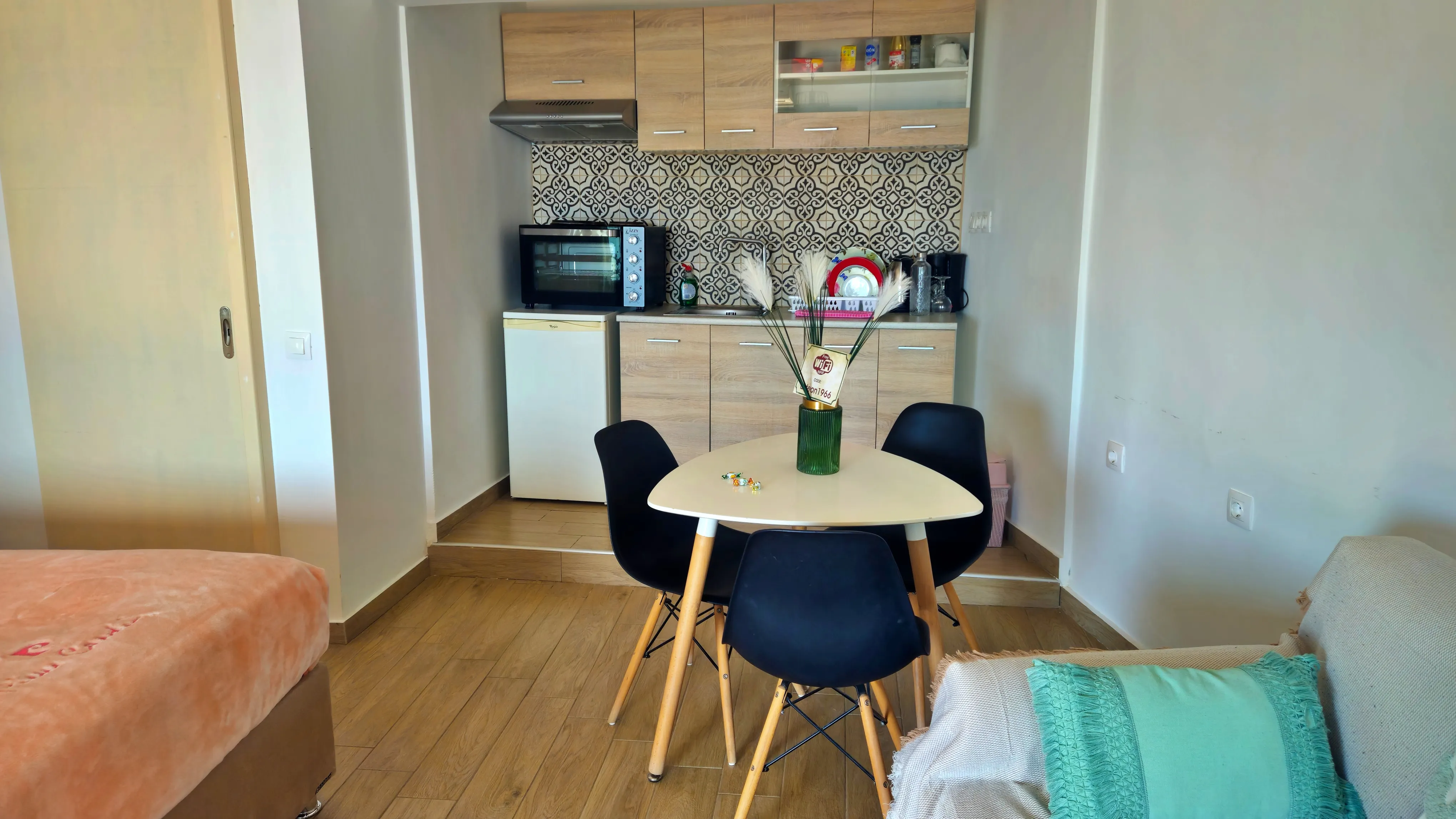 inside view of a hotel room featuring a small dining table and the kitchen in the background