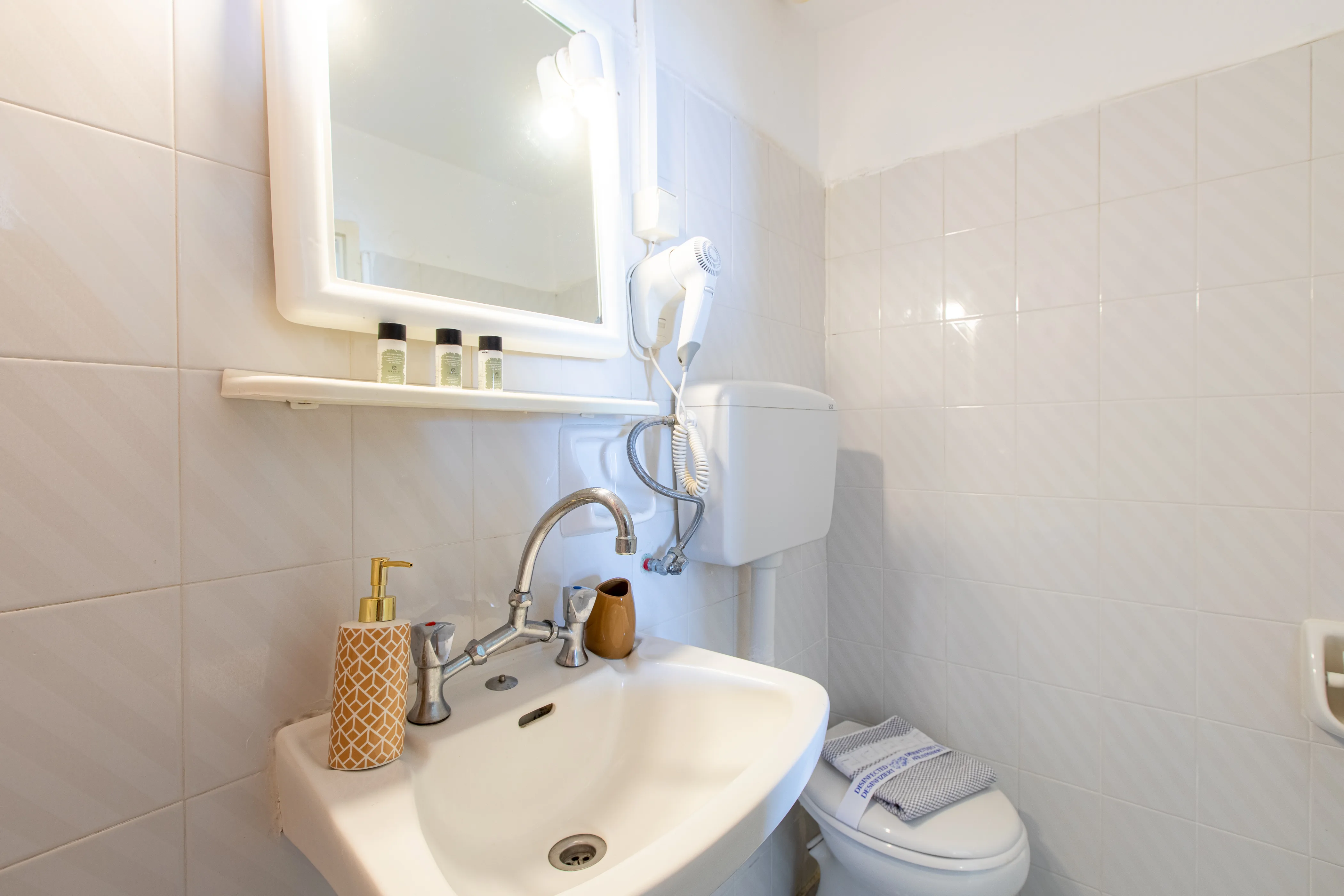 inside view of the bathroom featuring a white sink and a mirror above it